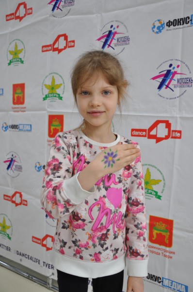 Юная участница с символом Дня борьбы с туберкулезом - ромашкой